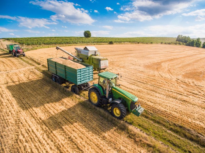 combine-harvester-pouring-grain-into-trailer-towed-by-tractor-picjumbo1-com